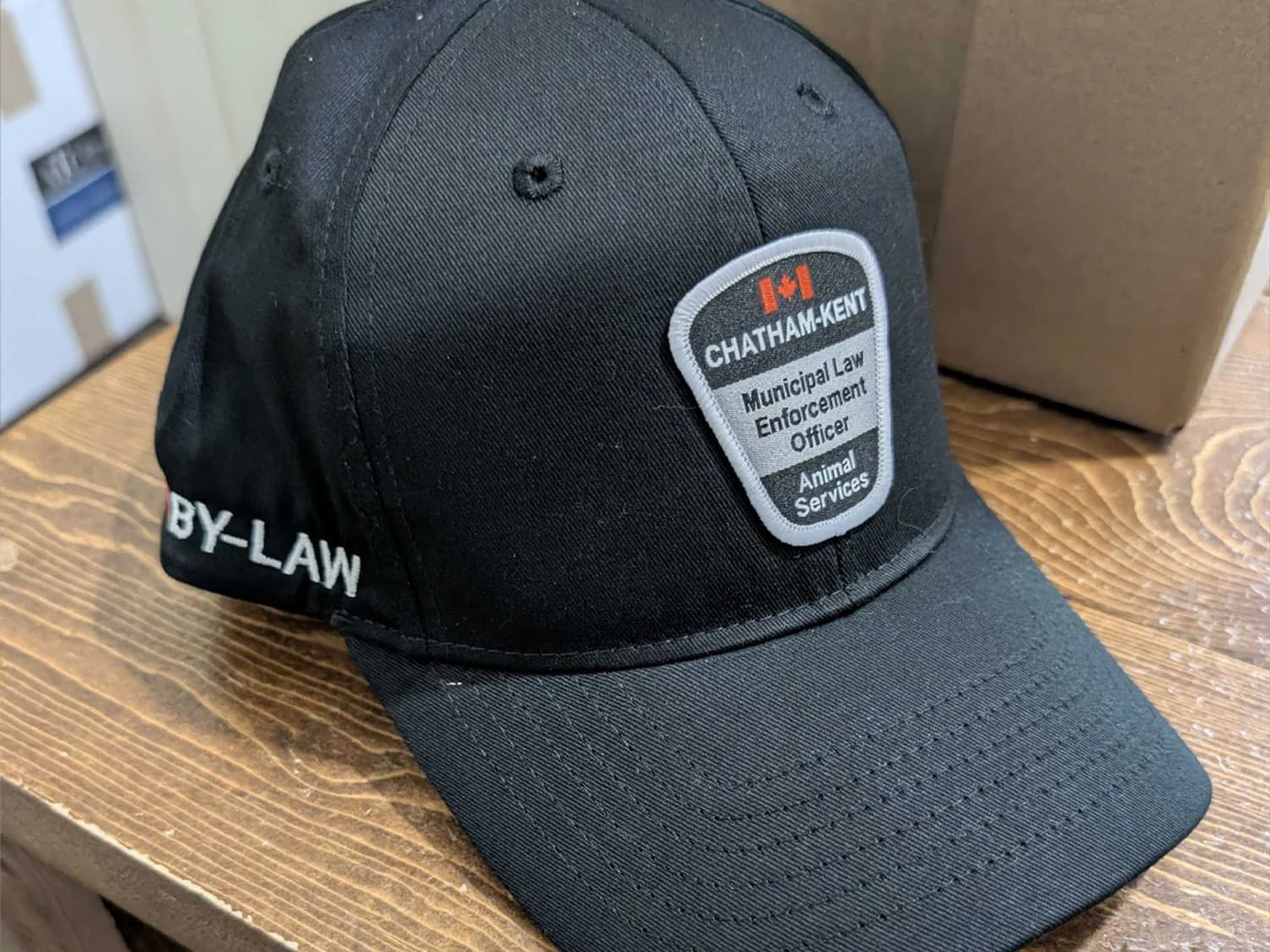 Custom Woven Patch Uniform Cap Black cap with a Chatham-Kent Animal Services woven patch on the front and white “BY-LAW” embroidery on the side.